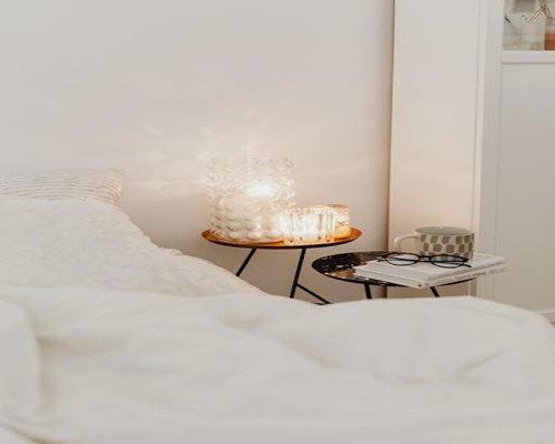 A cozy bedroom with soft warm lighting and a book on the side table